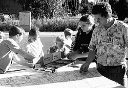 Ein Mann und mehrere Kinder betrachten einen Stadtplan.