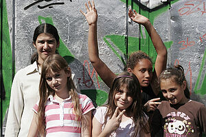 Fünf Mädchen stehen vor einer Wand, die mit Grafitti bemalt ist