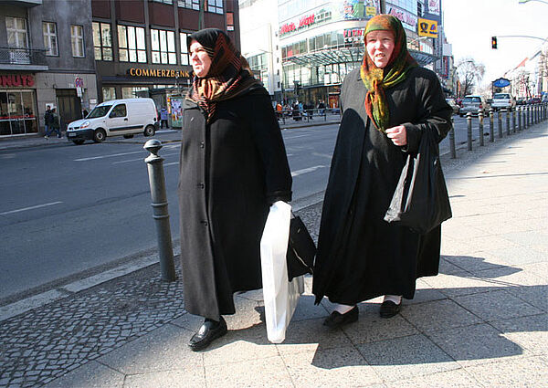 Zwei muslimische Frauen gehen eine Straße entlang
