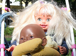 Zwei Puppen – eine mit blonden Haaren und eine dunkelhäutige