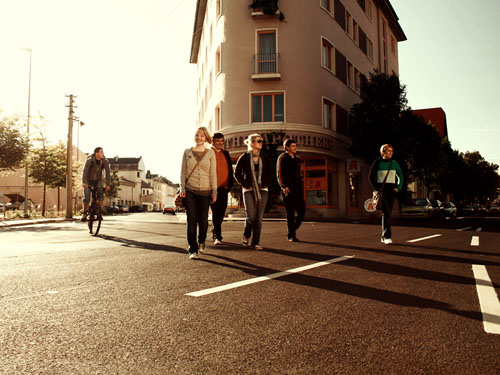 Einige junge Leute überqueren eine Straße in einem Stadtviertel