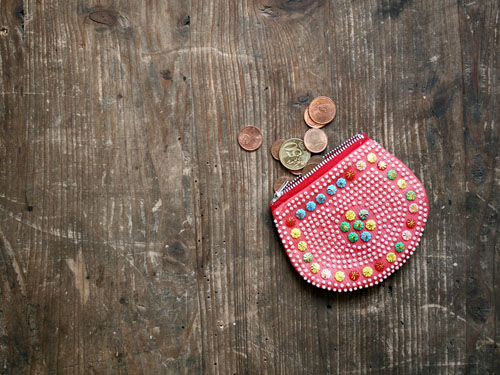 Eine Geldbörse mit Kleingeld auf einem Holztisch