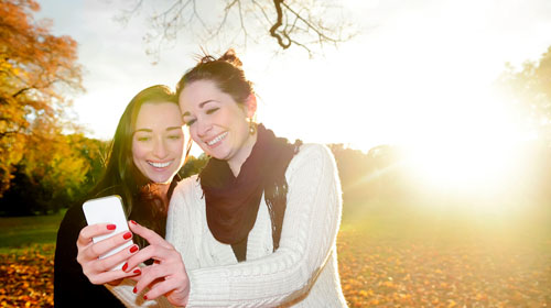 Zwei junge Frauen blicken auf ein Smartphone