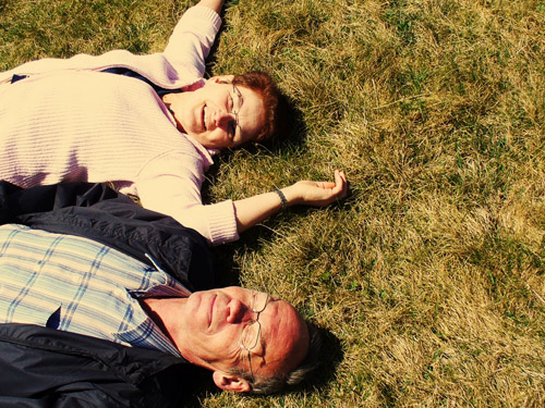 Zwei glückliche Senioren entspannen auf einer Wiese
