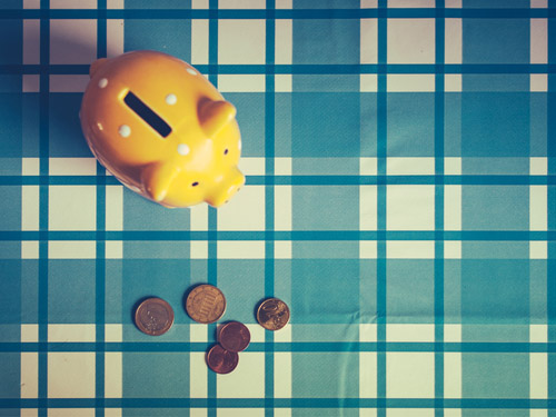 Ein Sparschwein und einige Münzen auf einem Tisch